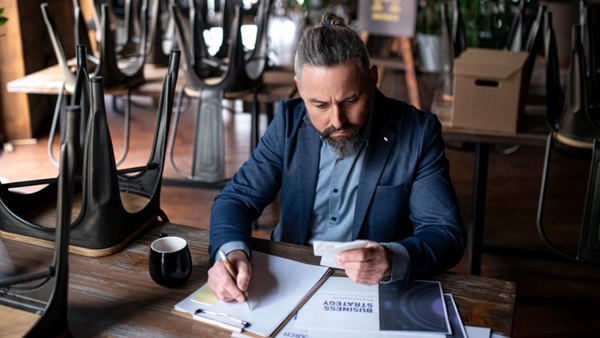 Mandlig restaurantejer laver regnskab