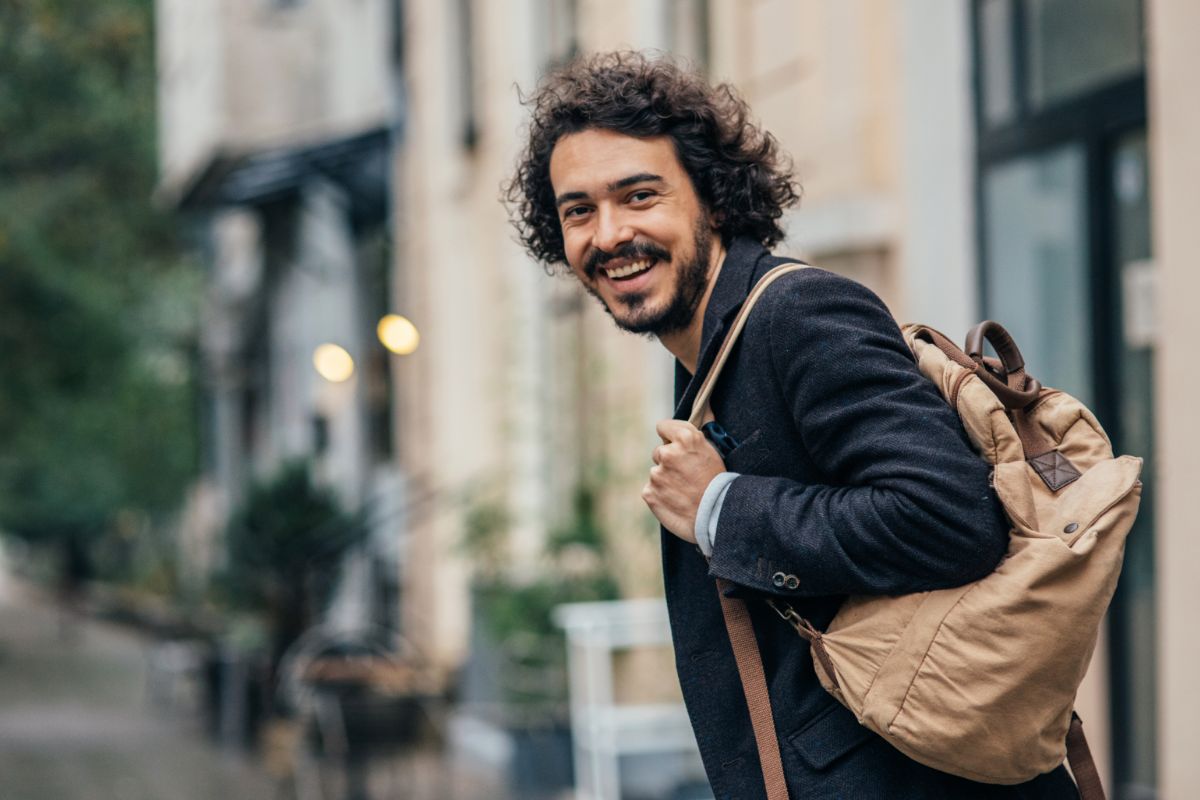 Mand med rygsæk smiler
